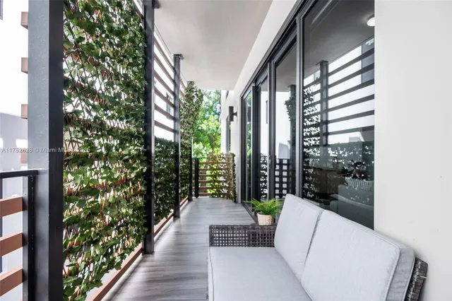 a porch with a bench and potted plants