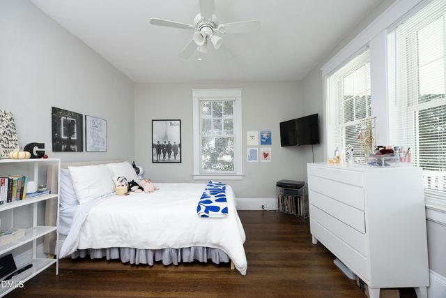 a bed room with a bed tv and a window