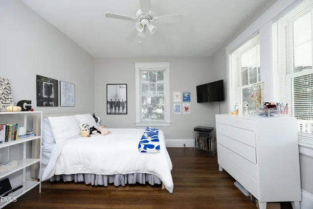 a bed room with a bed tv and a window