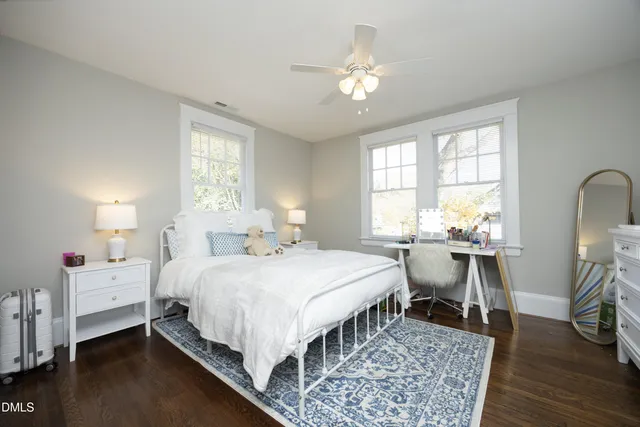 a bedroom with a bed a chandelier and dresser
