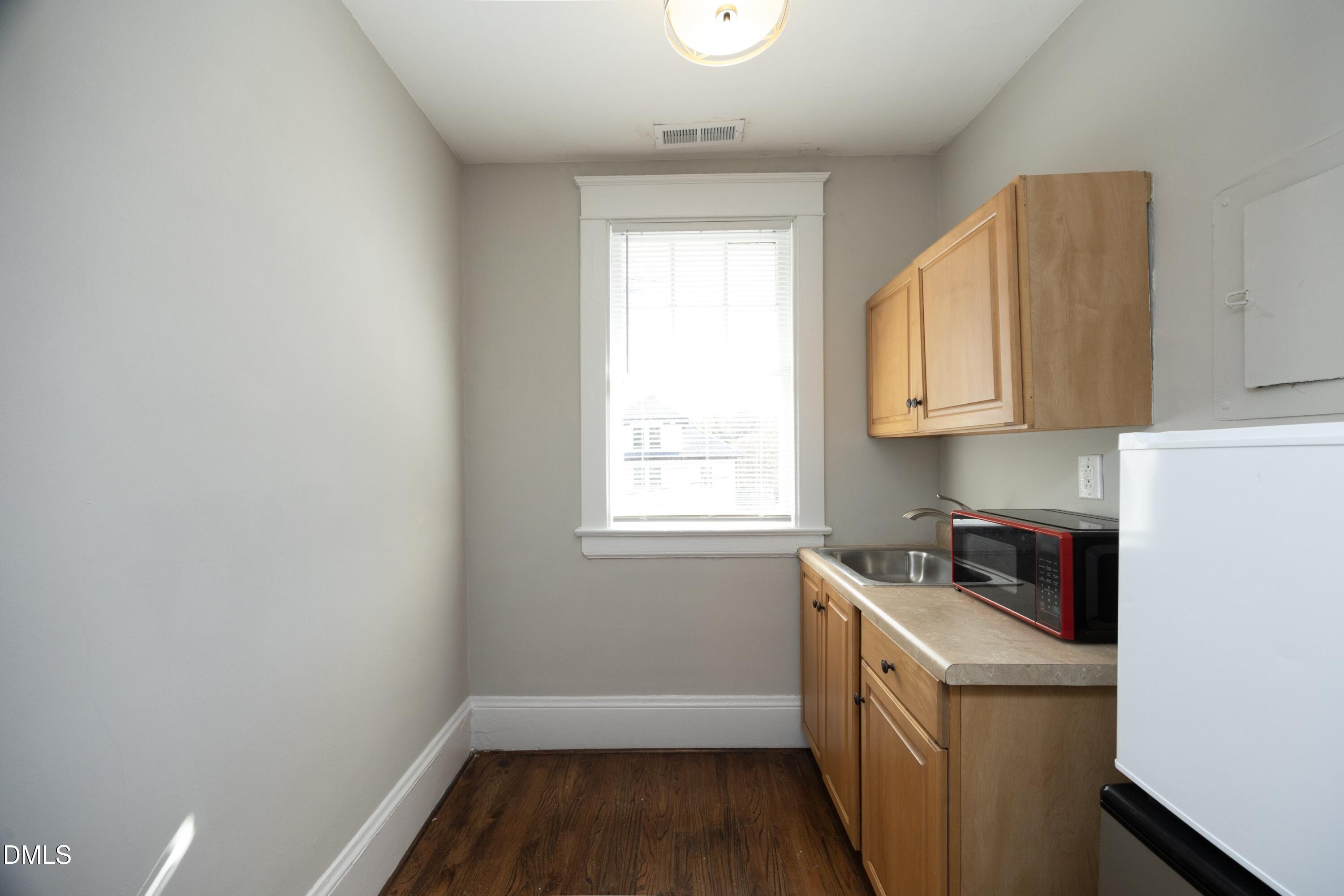 206 Ashe Avenue Raleigh, NC 27605 - Photo 29 of 37 a kitchen with a sink a stove and cabinets