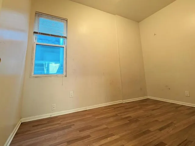 a view of a small space with wooden floor and a window