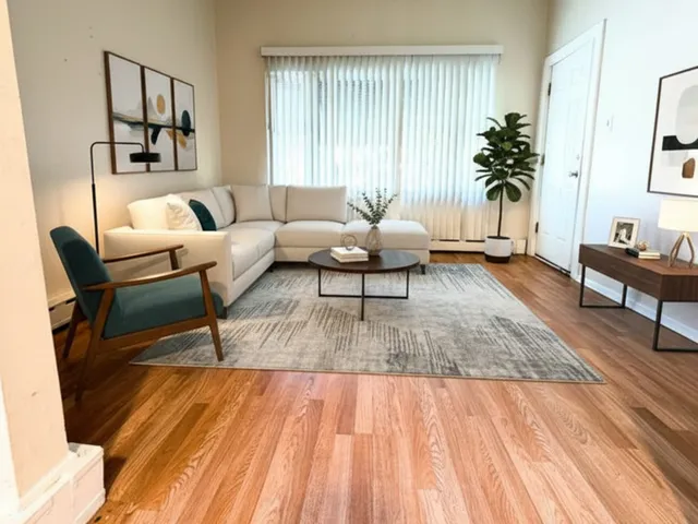 a living room with furniture and a wooden floor