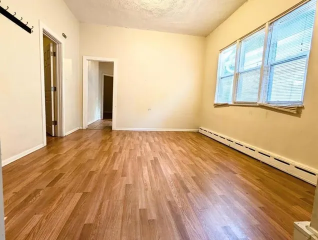 a view of a room with wooden floor and brick walls