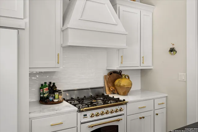 a kitchen with white cabinets and a stove