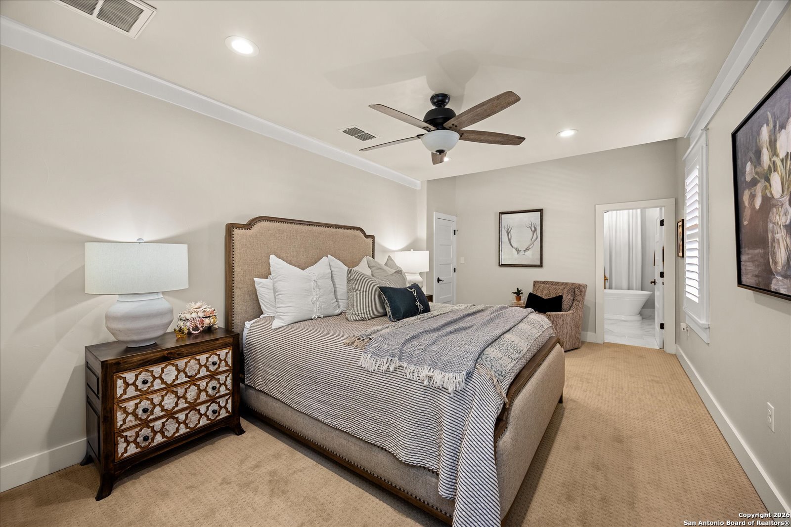 1006 High Street Comfort, TX 78013 - Photo 22 of 50 a spacious bedroom with a bed a couch and a chandelier