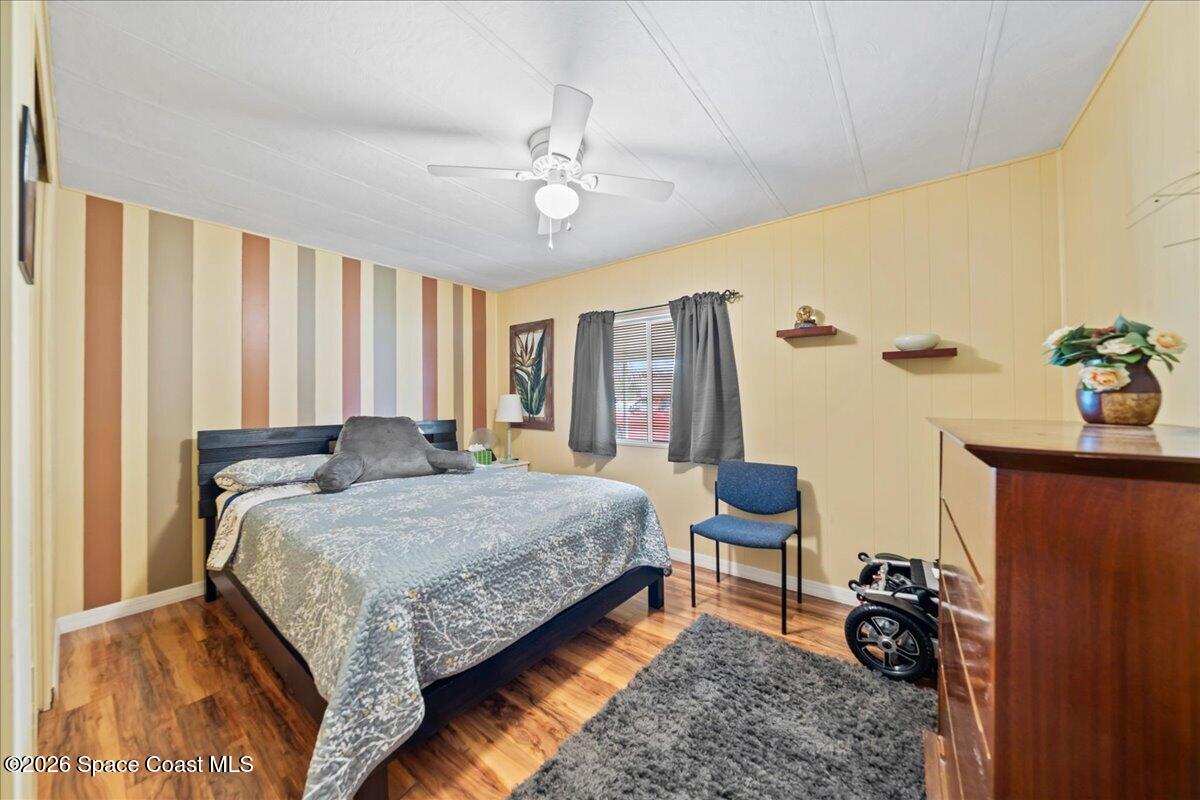 1740 Seagrape Street Northeast Palm Bay, FL 32905 - Photo 13 of 33 a bedroom with a bed and a chandelier