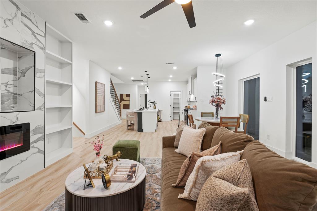 923 Walkway Street Dallas, TX 75212 - Photo 15 of 33 Living area with a fireplace, stairs, light wood-style floors, ceiling fan, and built in shelves