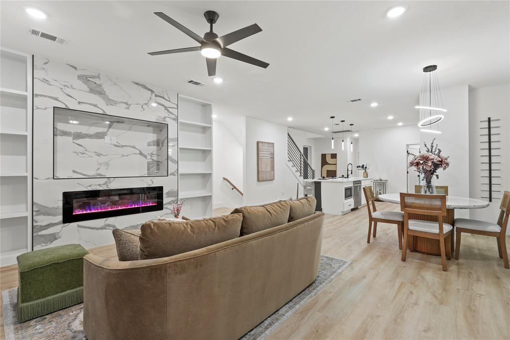 923 Walkway Street Dallas, TX 75212 - Photo 16 of 33 Living room featuring built in features, a fireplace, a ceiling fan, light wood-type flooring, and stairway