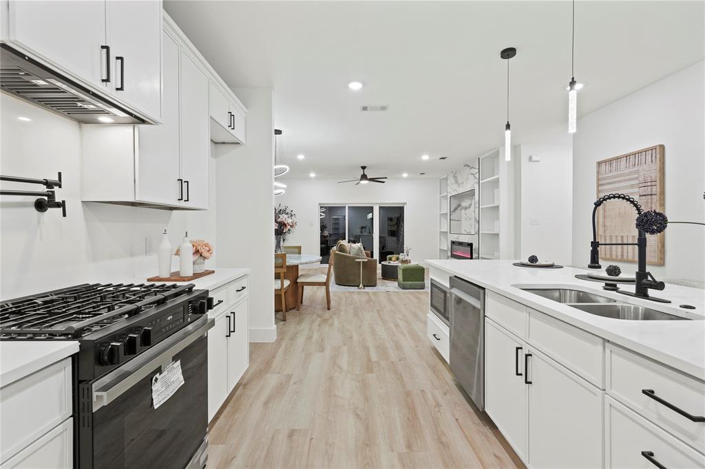 923 Walkway Street Dallas, TX 75212 - Photo 18 of 33 Kitchen with white cabinets, gas stove, decorative light fixtures, and recessed lighting