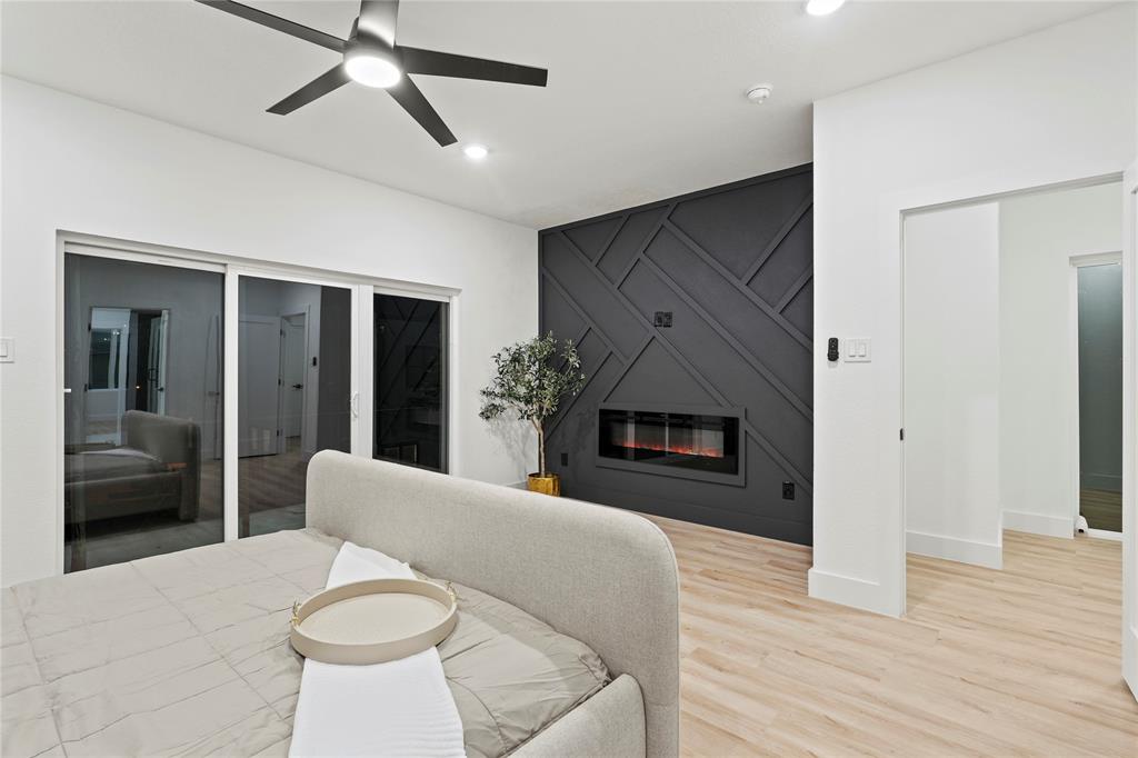 923 Walkway Street Dallas, TX 75212 - Photo 22 of 33 Bedroom with wood finished floors, ceiling fan, a large fireplace, and recessed lighting