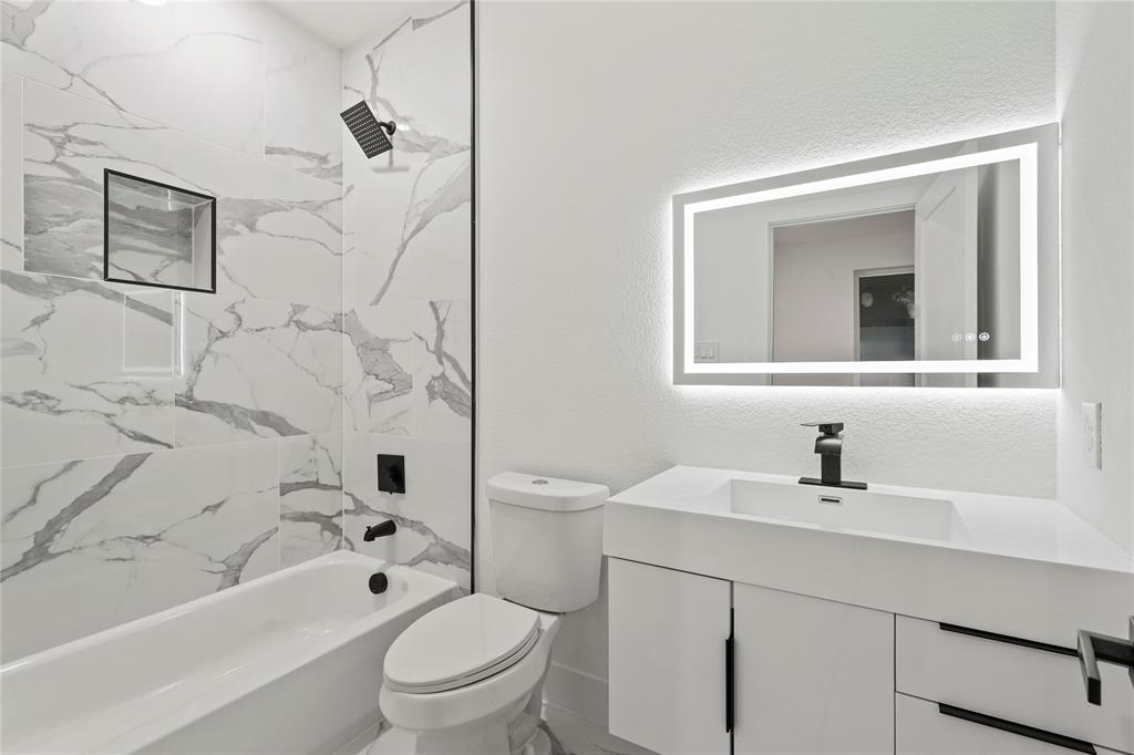 923 Walkway Street Dallas, TX 75212 - Photo 23 of 33 Bathroom featuring vanity, shower / tub combination, and a textured wall
