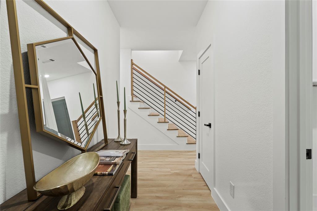 923 Walkway Street Dallas, TX 75212 - Photo 4 of 33 Hall featuring stairway, light wood finished floors, and a textured wall