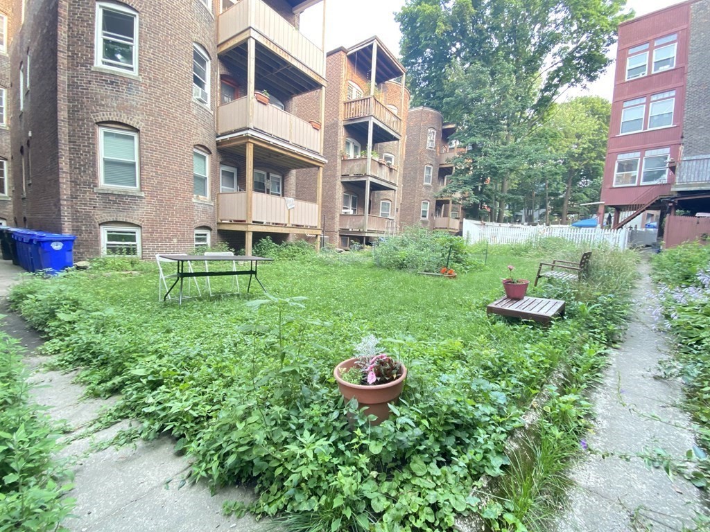 96 Naples Road, Unit 3 Brookline, MA 02446 - Photo 9 of 12 a view of a white house with a yard and garden