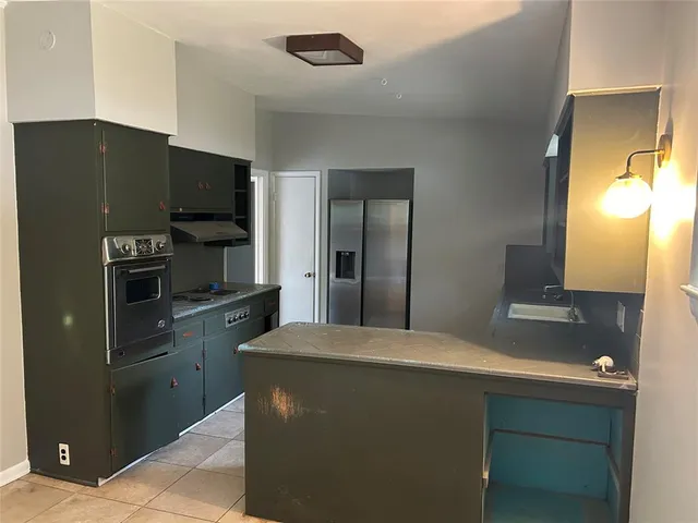 a kitchen with stainless steel appliances a refrigerator and a stove