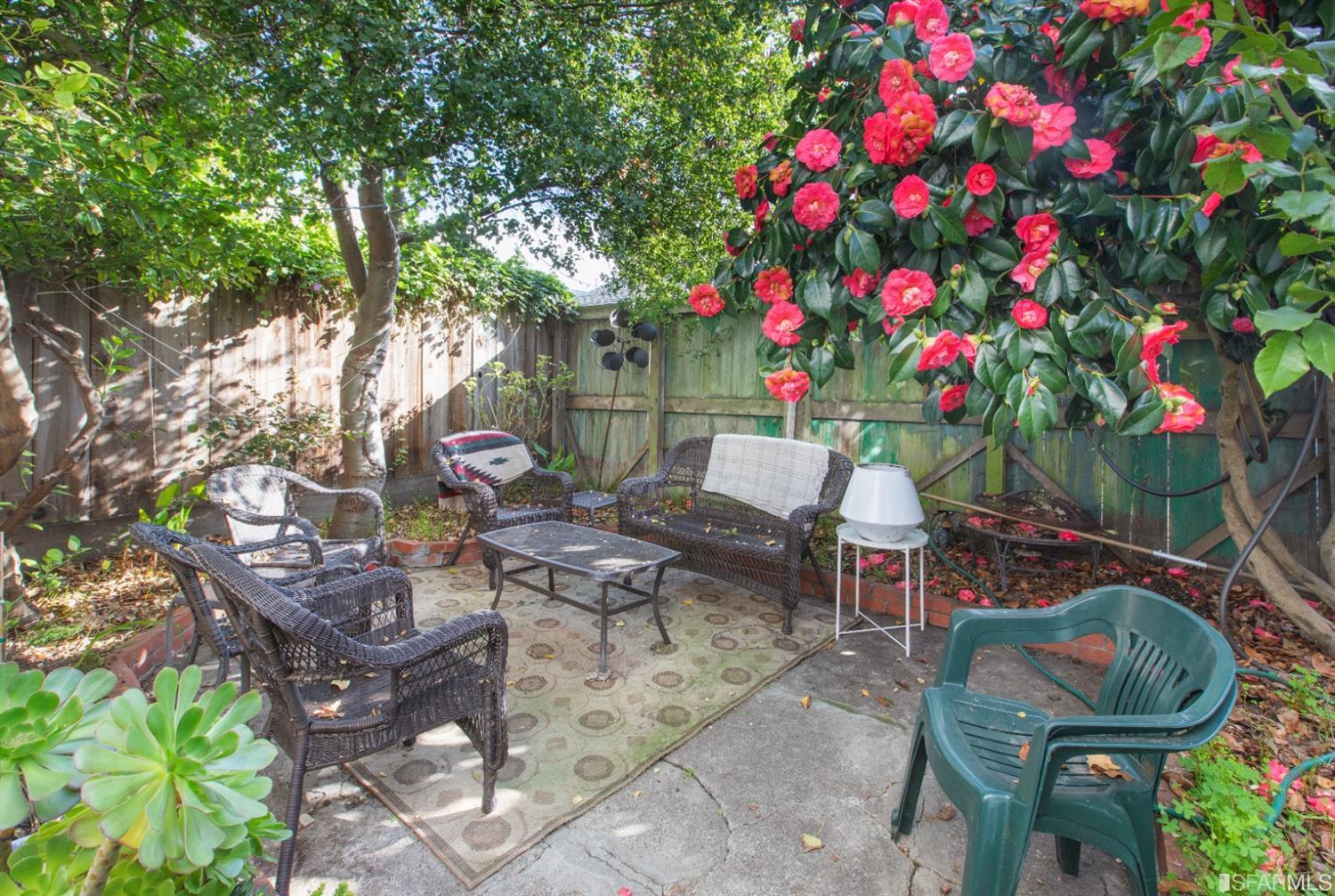 a backyard of a house with table and chairs and potted plants