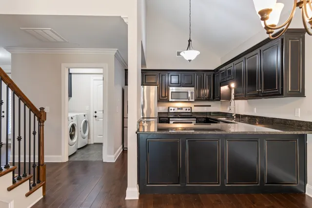 a kitchen with stainless steel appliances granite countertop a sink a stove and a refrigerator