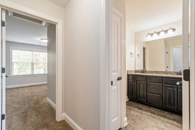 a bathroom with a granite countertop sink and a mirror