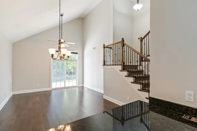 a view of a livingroom with wooden floor and stairs