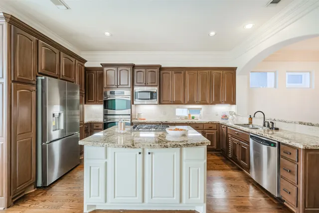 a kitchen with stainless steel appliances granite countertop a sink stove and refrigerator