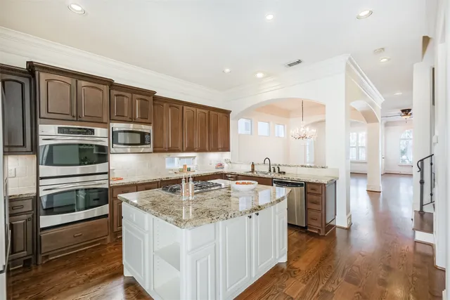 a kitchen with a stove a sink and a wooden cabinets