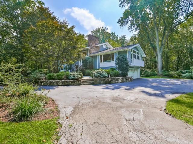 a front view of a house with a yard and trees