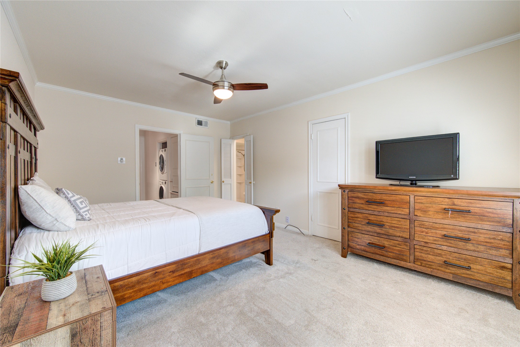 2232 South Piney Point Road, Unit 110 Houston, TX 77063 - Photo 10 of 21 Spacious primary bedroom featuring plush carpeting, elegant plantation shutters, ceiling fan, and ample space for a king-sized bedroom suite, creating a comfortable and relaxing retreat.