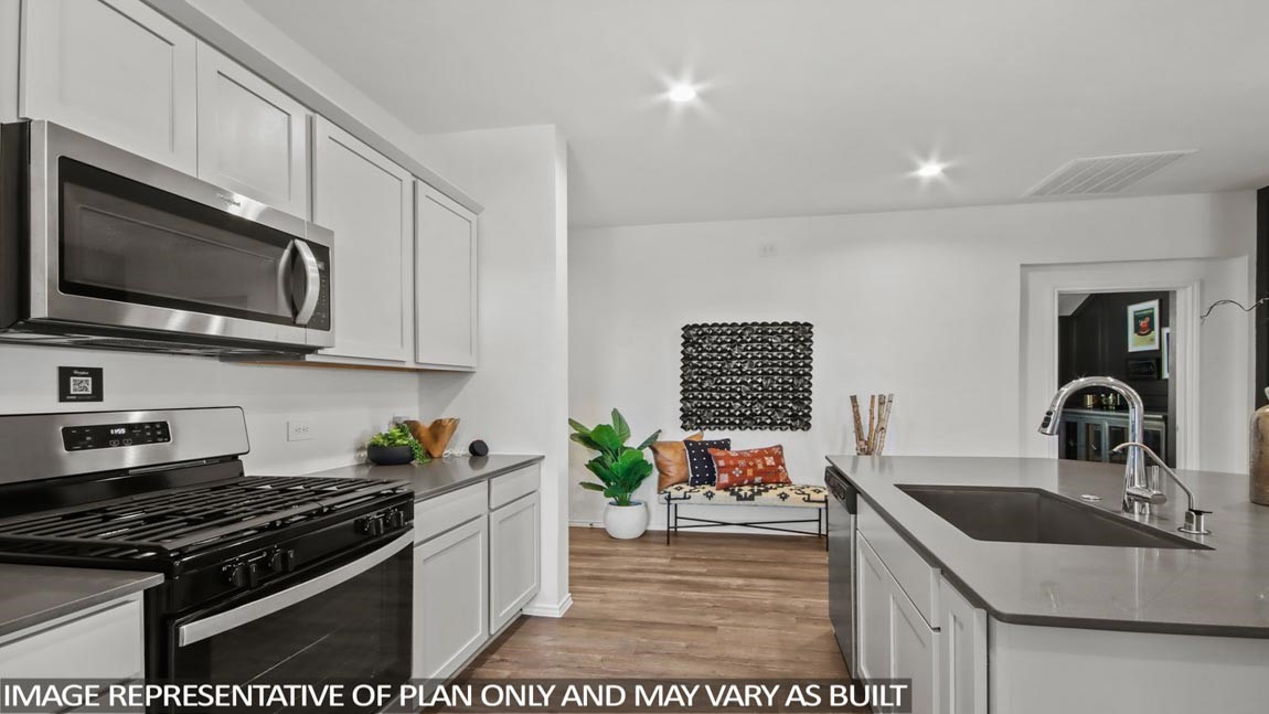 4226 Multnomah Falls Drive Conroe, TX 77303 - Photo 5 of 31 a kitchen with stainless steel appliances granite countertop a sink stove and microwave