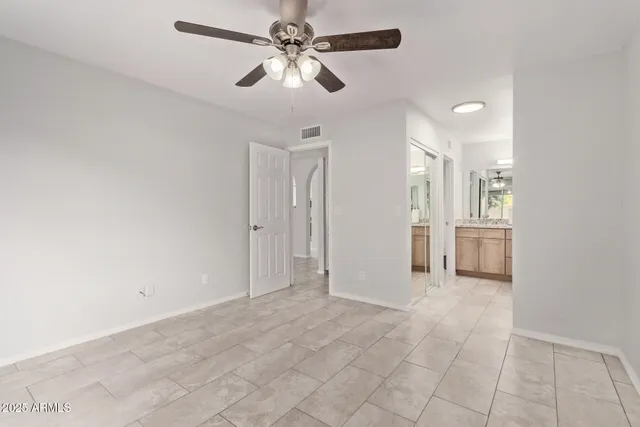 a view of a hallway with a chandelier fan and windows