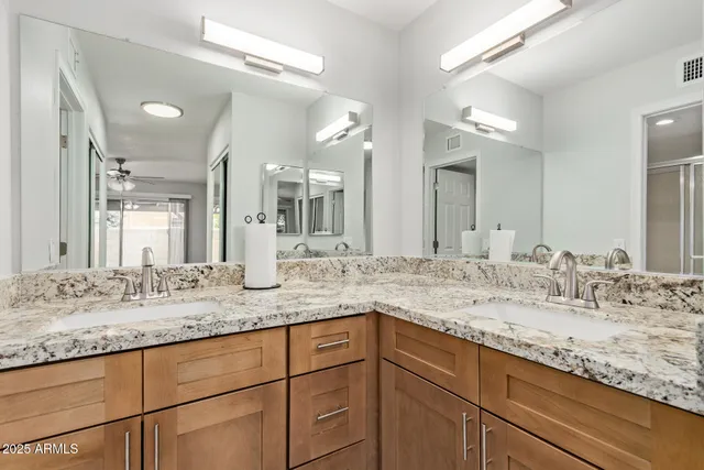 a bathroom with a granite countertop sink double and mirror