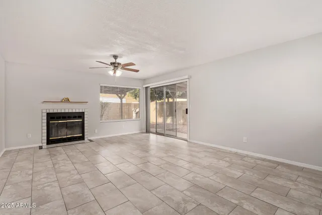 a view of an empty room with a fireplace and a window