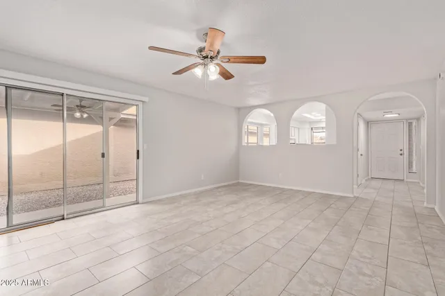 an empty room with fan and windows