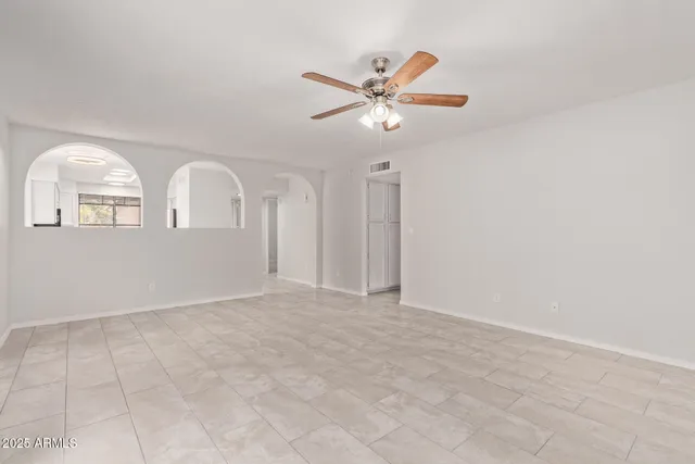 an empty room with fan and windows