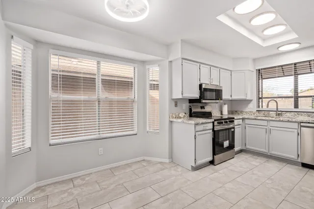 a kitchen with granite countertop a stove a sink and a microwave