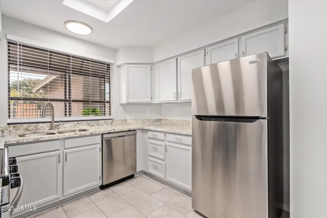 a kitchen with stainless steel appliances granite countertop a refrigerator and a sink