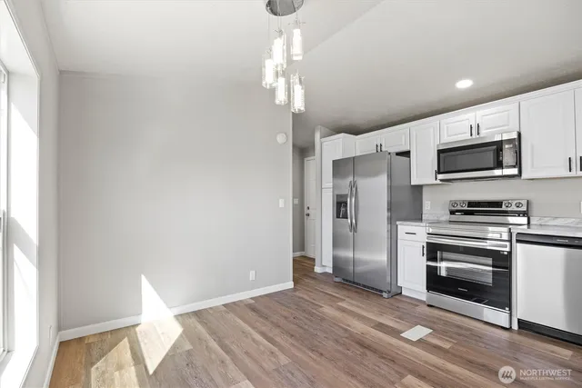 a view of kitchen with wooden floor electronic appliances and window