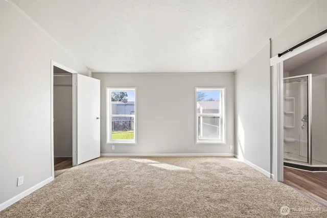 an empty room with windows and closet