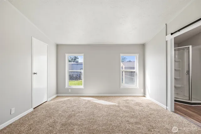 an empty room with windows and closet