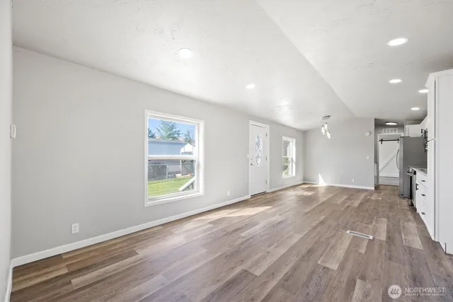 an empty room with wooden floor and a window