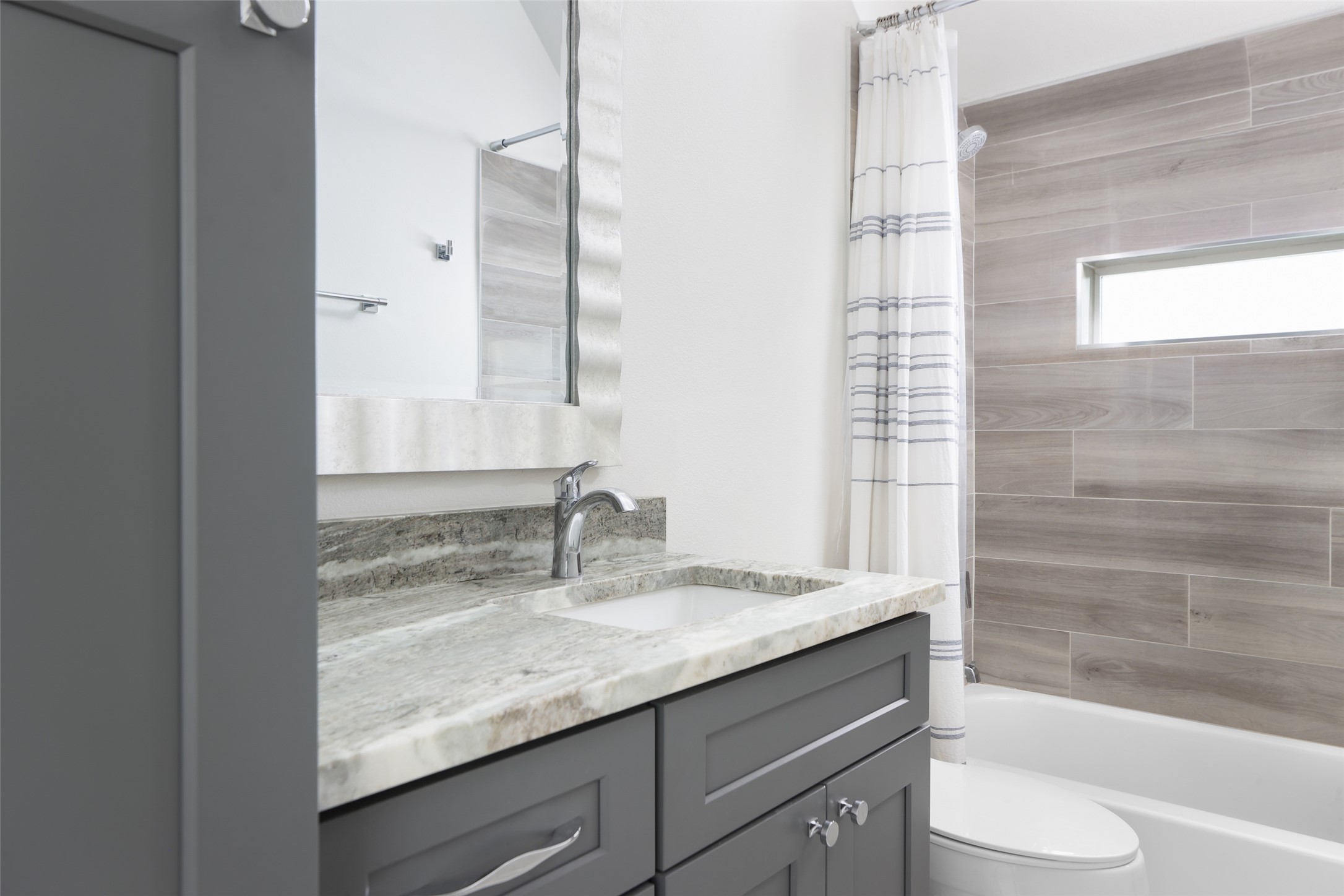 1120 Omega Avenue, Unit 1 Austin, TX 78721 - Photo 17 of 24 a bathroom with a granite countertop sink toilet and shower