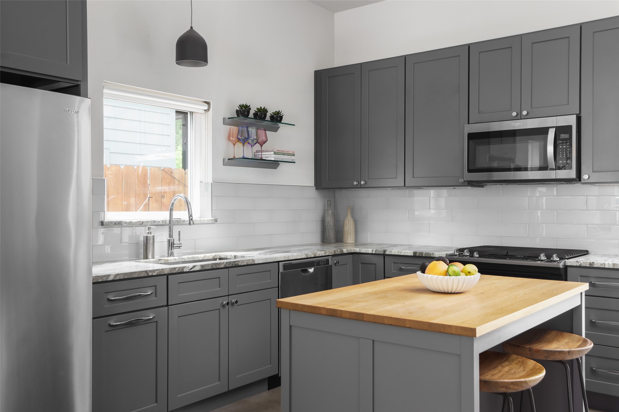 1120 Omega Avenue, Unit 1 Austin, TX 78721 - Photo 4 of 24 a kitchen with a sink a microwave and cabinets