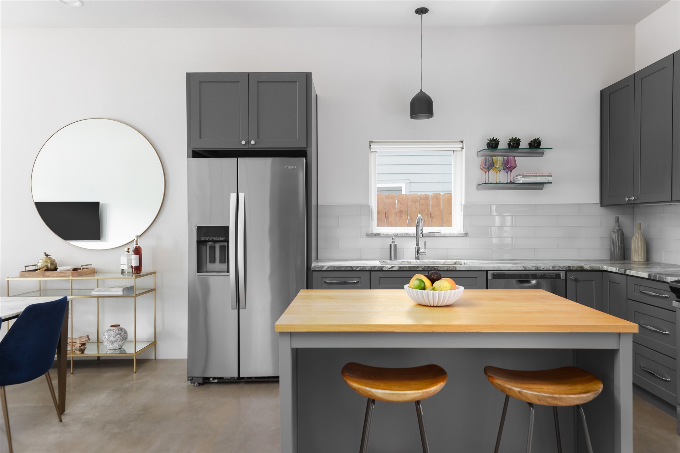 1120 Omega Avenue, Unit 1 Austin, TX 78721 - Photo 5 of 24 a kitchen with stainless steel appliances a stove a refrigerator and a dining table with wooden floor