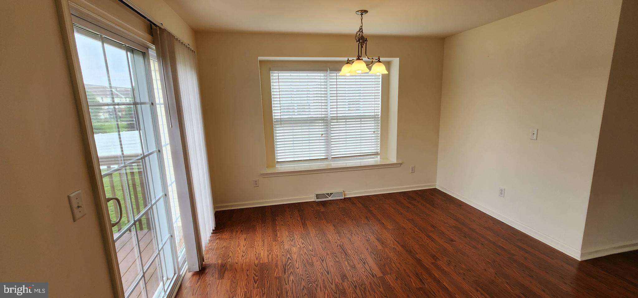 335 Paradee Drive Dover, DE 19904 - Photo 13 of 45 a view of an empty room with wooden floor and a window