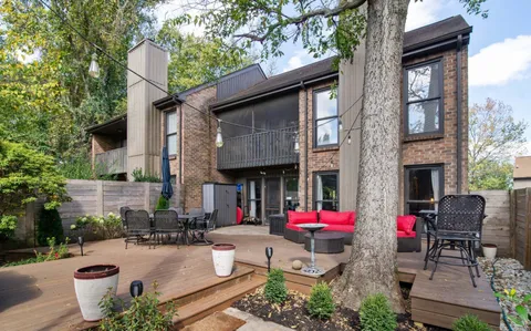a view of the patio with dining table and chairs and potted plants