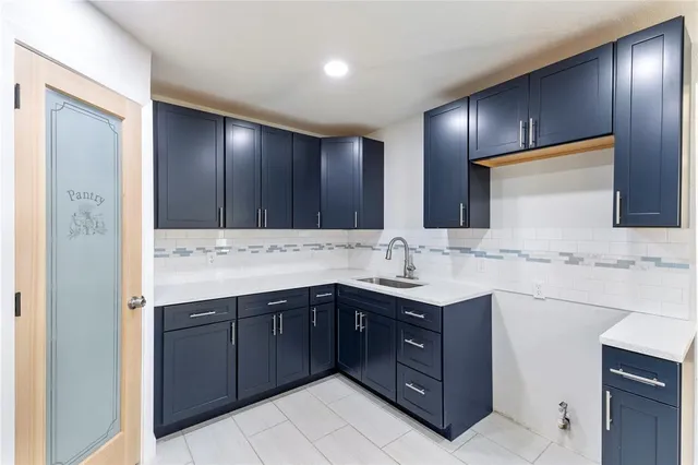 a large kitchen with granite countertop a sink and dishwasher a oven with wooden cabinets