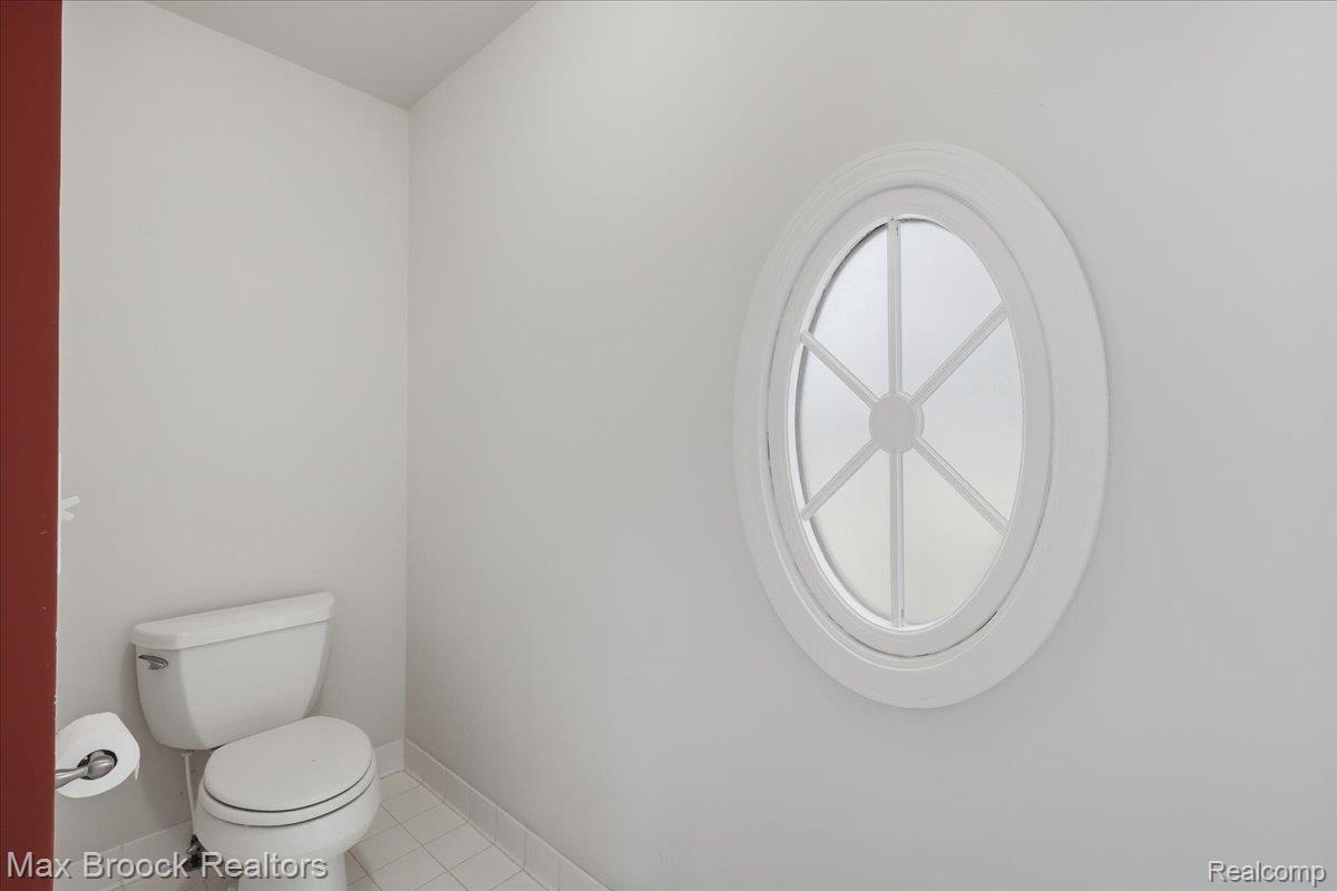 1731 Rico Road Commerce Township, MI 48382 - Photo 27 of 48 Oval window with decorative mullions, white walls, and white floor tiling