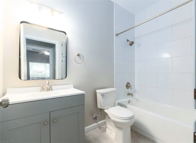 a bathroom with a toilet sink vanity tub and mirror