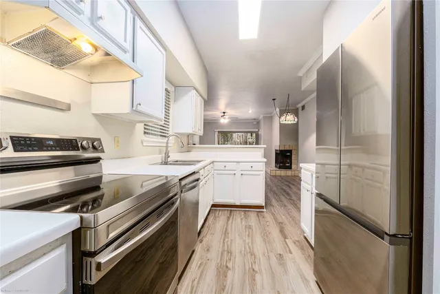 a kitchen with stainless steel appliances a stove a sink and a refrigerator