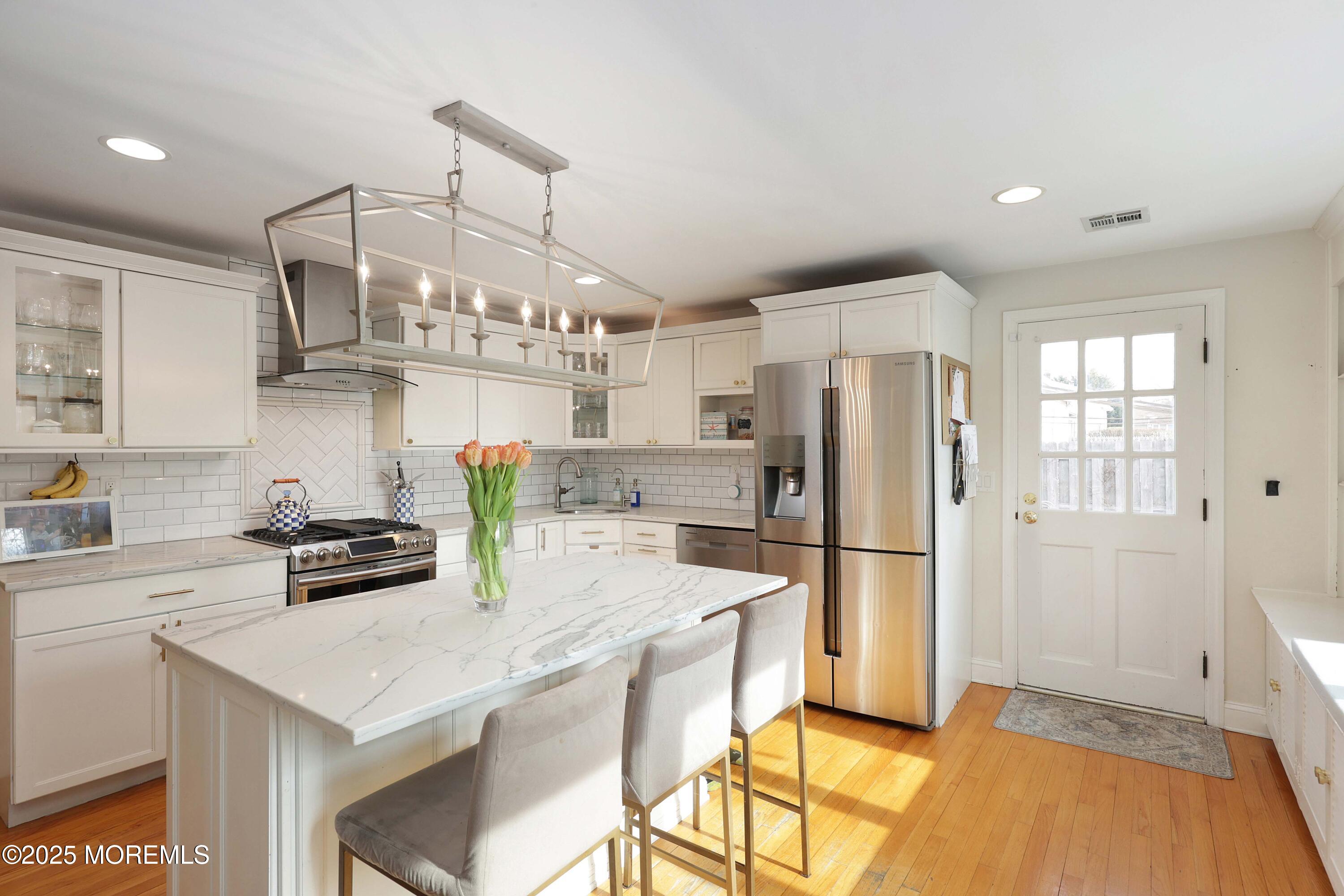29 SilverWhite Road Little Silver, NJ 07739 - Photo 11 of 38 a kitchen with stainless steel appliances a stove a refrigerator a sink a dining table and chairs