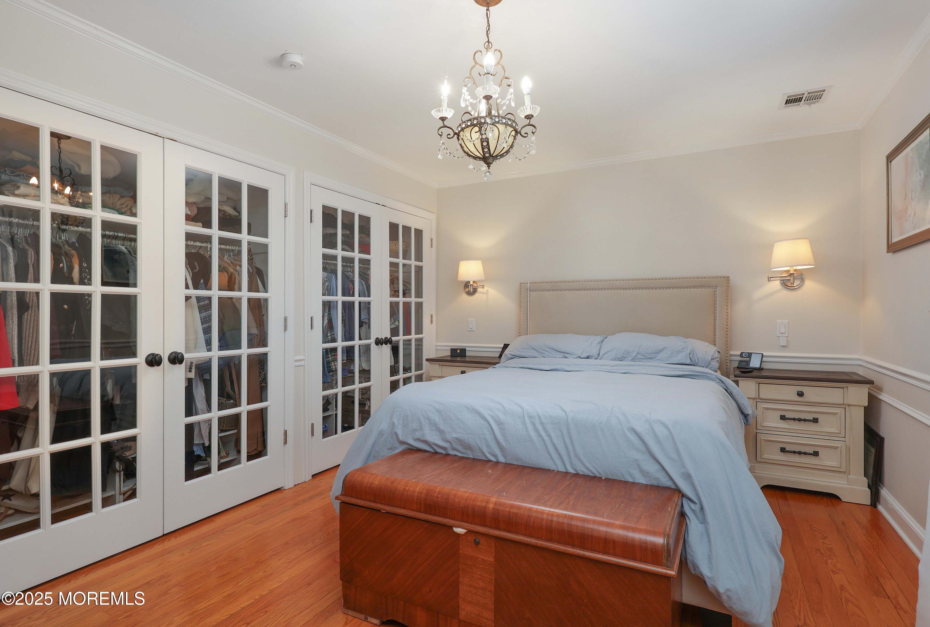 29 SilverWhite Road Little Silver, NJ 07739 - Photo 19 of 38 a bedroom with a large bed and a chandelier
